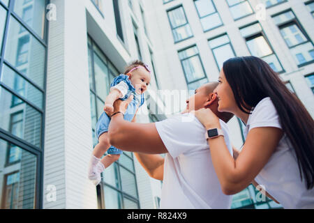 Ehepaar, Aman, Kind, Frau, Mann, der auf seinen Schultern. gegen Hintergrund Gebäude aus Glas Stockfoto