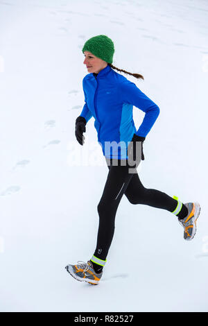 Weibliche Jogger auf einen Lauf, im Winter im Schnee Stockfoto