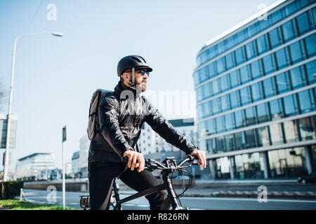 Männliche Kurier mit dem Fahrrad die Auslieferung von Paketen in der Stadt. Kopieren Sie Platz. Stockfoto