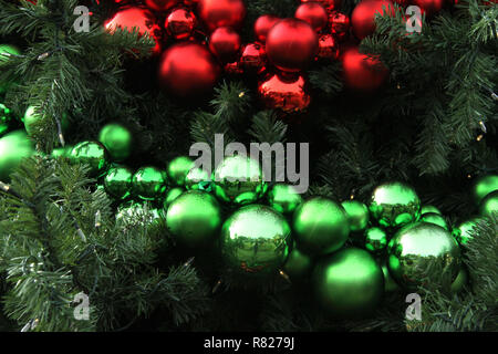 Rot und Grün Weihnachtsverzierungen in großen künstlichen Baum Stockfoto