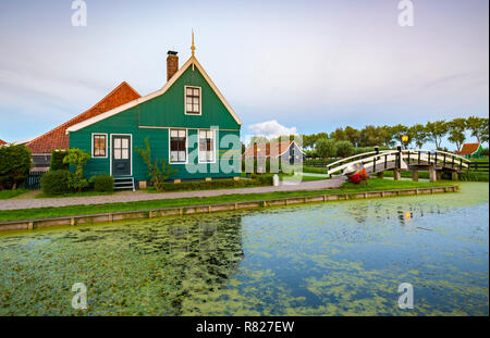 In der Regel traditionelle holländische Haus, Windmühle, historische Architektur und die Brücke über Wasser in Zaanse Schans, beliebte touristische Sehenswürdigkeit. Stockfoto