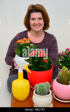 Eine Hausfrau die Pflege von Pflanzen in Töpfen Stockfoto