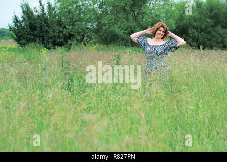 Schönen lächelnden Frau mittleren Alters in der Natur im Sommer Stockfoto