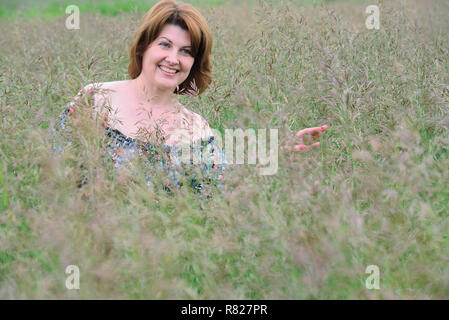 Portrait der Frau in das Gras im Sommer Stockfoto