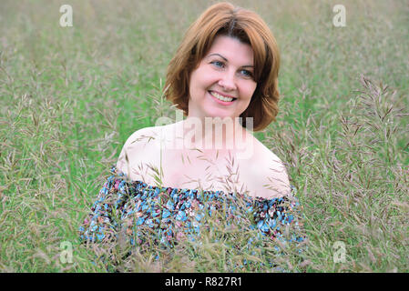 Portrait der Frau in das Gras im Sommer Stockfoto