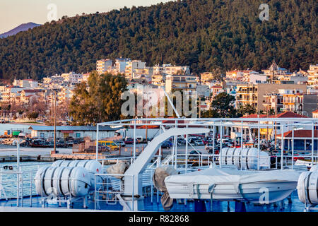 IGOUMENITSA, Griechenland - 2. MÄRZ 2017: letzte Strahlen von Licht der untergehenden Sonne fallen auf die griechische Stadt Igoumenitsa, Stadt, Gebäude, geparkte Fahrzeuge und Stockfoto