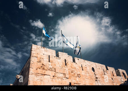 Israel und Jerusalem Flaggen über Jerusalem alte Stadtmauern gegen den blauen Himmel mit weißen Wolken im sonnigen Sommer Licht Stockfoto