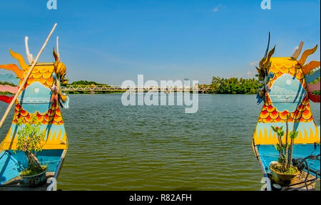 Die beiden hell Maler Sie prows eines Drachenboot Anfahren einer Brücke auf den Perfume River Hue, Vietnam. Stockfoto