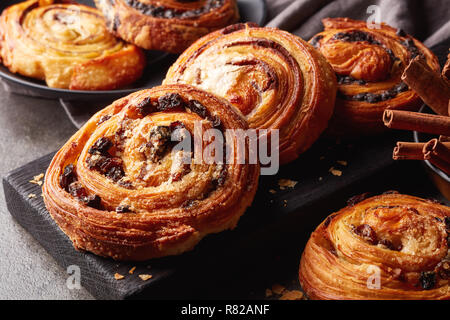 Frisch gebackene süße Brötchen am Schwarzen Brett auf grauem Stein Hintergrund Stockfoto