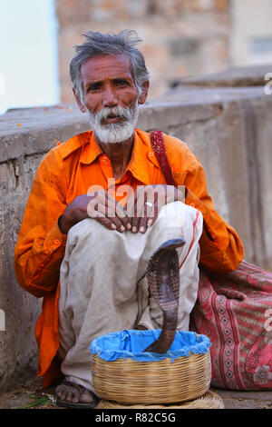 Lokalen Schlangenbeschwörer sitzen auf der Straße von Jaipur, Indien. Jaipur ist die Hauptstadt und größte Stadt im indischen Bundesstaat Rajasthan. Stockfoto