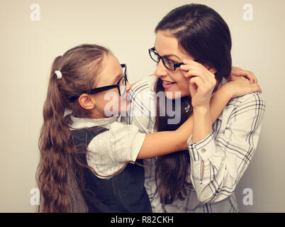 Gerne überraschende Mutter und Excite Kid Mode Brille suchen und kuscheln sich leere Raum blauen Hintergrund. Stockfoto