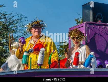 Nachtschwärmer werfen Schmuckstücke der Menge, die wie ihre schwimmstellung bewegt sich der Canal Street in der Innenstadt von Mobile, Ala., während der Joe Cain Prozession an der Mardi Gras. Stockfoto