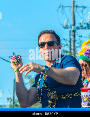 Ein Nachtschwärmer wirft Mardi Gras Perlen in der Masse als seine Schwimmer sich entlang der Canal Street in Mobile, Alabama während der Joe Cain Day Parade am Mardi Gras. Stockfoto