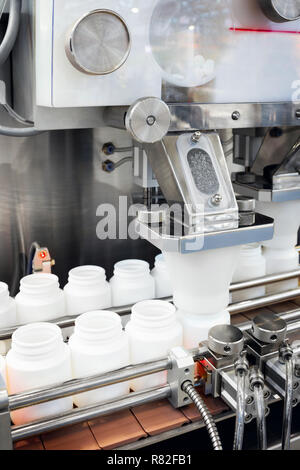 Pharmazeutische Industrie, Medizin Pillen sind Füllung in die Plastikflasche an Linie Maschine Förderband an der Medizinischen Werk. Selektive konzentrieren. Stockfoto