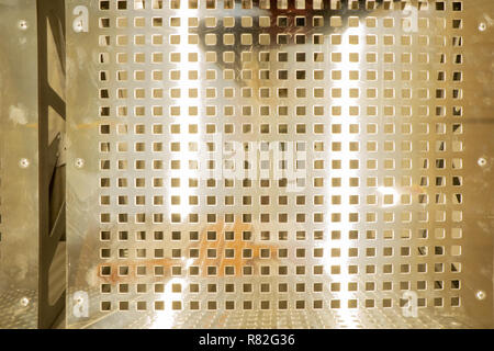 Metall Hintergrund Punktmuster. Textur aus gelochtem Edelstahl. Bank aus Metall. Ansicht von oben Stockfoto