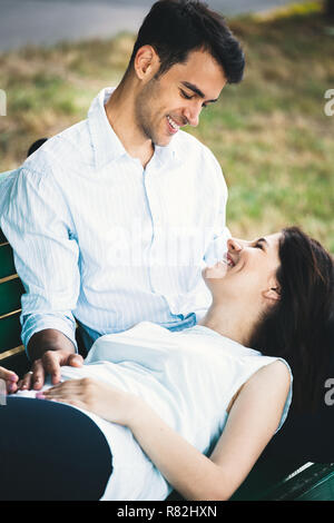 Junge Frau liegt auf dem mans Knie und Suchen, auf ihn lächelnd. Happy people portrait. Stockfoto