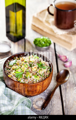 Buchweizen Porridge mit Knochenmark, Schnittlauch, salzige Gurken und Koriander auf dem hölzernen Tisch Stockfoto