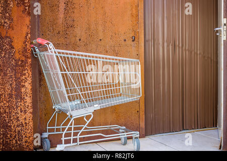 Warenkorb auf Rusty Hintergrund weiter alte Tür geöffnet Stockfoto