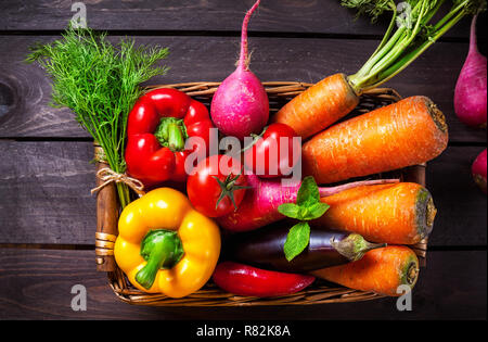 Korb mit verschiedenen Gemüse auf dem Holztisch in der Küche Stockfoto