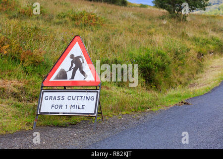 UK Dreieck Schild Warnung von Gras schneiden für eine Meile Stockfoto