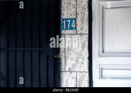 Weiße Holztür mit der Nummer 174 auf Grunge außen Fliesen Wand Stockfoto