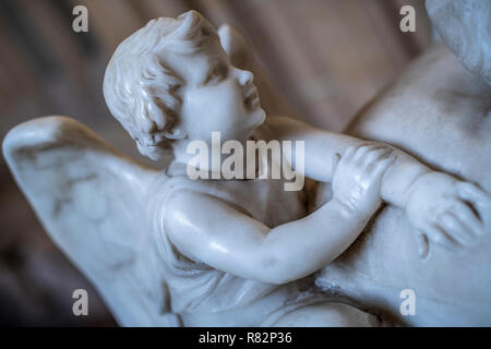 Ein Marmor Cherub sitzt an der Spitze einer Grab in der Kathedrale von Wells, Somerset. Stockfoto