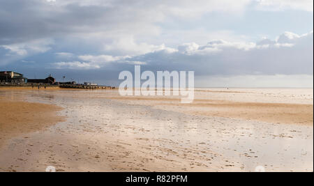 Die Menschen in der Ferne einen hellen Boxen Tag morgen zu Fuß bei Ebbe am Strand von Lytham St. Anne's genießen. Stockfoto