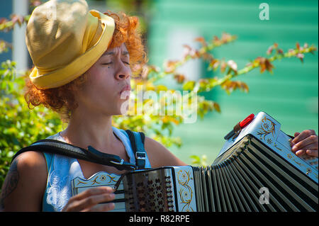 Portland, Oregon, USA - 17. August 2014: eine Straße, Entertainer, spielen eine accordian während Pfeifen, am Weißdorn jährliche Street Fair Stockfoto