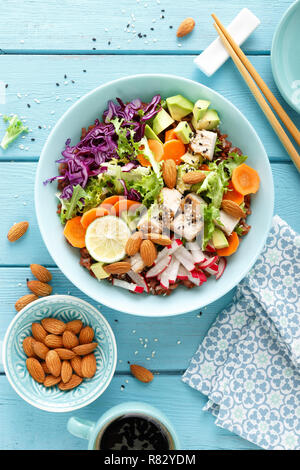 Schüssel mit gegrilltem Hähnchenfleisch, brauner Reis und frisches Gemüse Salat mit Avocado, Rettich, Kohl Kohl, Möhre und Salat verlässt. Gesunde und delicio Stockfoto