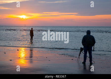 Liverpool, Merseyside, UK. 12. Dezember, UK Wetter: die Zahlen sehen, um den Sonnenuntergang am Crosby Beach. Die anderen Ort Bügeleisen Männer zahlen - jeder mit einem Gewicht von 650 Kilo - werden aus wirft der Künstler, Anthony Gormley, eigenen Körper in einer Pfütze auf dem Strand, alle mit Meerblick. Nachdem ich vorher in Cuxhaven in Deutschland, Stavanger in Norwegen und in De Panne in Belgien gesehen worden, "einem anderen Ort" ist nun ein fester Bestandteil im Vereinigten Königreich. Credit: MediaWorldImages/Alamy leben Nachrichten Stockfoto