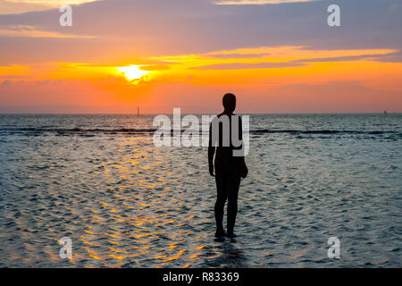 Liverpool, Merseyside, UK. 12. Dezember, UK Wetter: die Zahlen sehen, um den Sonnenuntergang am Crosby Beach. Die anderen Ort Bügeleisen Männer zahlen - jeder mit einem Gewicht von 650 Kilo - werden aus wirft der Künstler, Anthony Gormley, eigenen Körper in einer Pfütze auf dem Strand, alle mit Meerblick. Nachdem ich vorher in Cuxhaven in Deutschland, Stavanger in Norwegen und in De Panne in Belgien gesehen worden, "einem anderen Ort" ist nun ein fester Bestandteil im Vereinigten Königreich. Credit: MediaWorldImages/Alamy leben Nachrichten Stockfoto