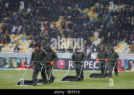 Kiew, Ukraine. 12 Dez, 2018. Groundstaff löscht Schnee aus dem Bereich vor dem UEFA Champions League Gruppe F Fußballspiel zwischen Shakhtar Donetsk und Lyon an der NSK Olimpiyskyi in Kiew, Ukraine, 12. Dezember 2018. Credit: anatolii Stepanov/ZUMA Draht/Alamy leben Nachrichten Stockfoto