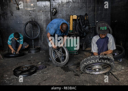 Caracas, Venezuela. 11 Dez, 2018. Venezolaner Reparatur Mäntel in einem Workshop. Angesichts der Wirtschaftskrise, alles, was in Venezuela wird repariert, bis es vollkommen nutzlos ist. Die venezolanische Inland leidet unter der Wirtschaftskrise. Nach Angaben des Internationalen Währungsfonds (IWF), der Südamerikanischen Land ist die Überschrift für die Inflationsrate von 1,37 Millionen Prozent im Jahr 2018. Credit: Rayner Pena/dpa/Alamy leben Nachrichten Stockfoto