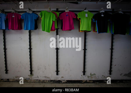 Caracas, Venezuela. 11 Dez, 2018. T-Shirts hängen in einem halb leeren Speicher in der venezolanischen Hauptstadt. Die wirtschaftliche Krise in Venezuela ist auch auf kleinere Läden. Nach Angaben des Internationalen Währungsfonds (IWF), der Südamerikanischen Land ist die Überschrift für die Inflationsrate von 1,37 Millionen Prozent im Jahr 2018. Credit: Rayner Pena/dpa/Alamy leben Nachrichten Stockfoto