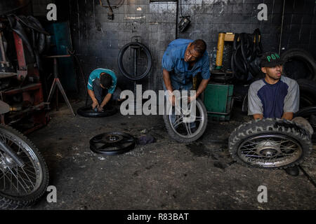 Caracas, Venezuela. 11 Dez, 2018. Venezolaner Reparatur Mäntel in einem Workshop. Angesichts der Wirtschaftskrise, alles, was in Venezuela wird repariert, bis es vollkommen nutzlos ist. Die venezolanische Inland leidet unter der Wirtschaftskrise. Nach Angaben des Internationalen Währungsfonds (IWF), der Südamerikanischen Land ist die Überschrift für die Inflationsrate von 1,37 Millionen Prozent im Jahr 2018. Credit: Rayner Pena/dpa/Alamy leben Nachrichten Stockfoto