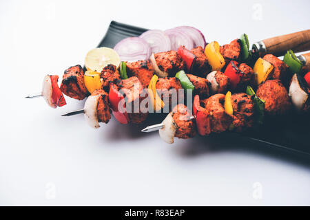 Chicken Tikka/skew Kebab. Traditionelle indische Gericht gekocht auf Holzkohle und Flamme, gewürzt & bunt garniert. Mit grüner Chutney und Salat serviert. Stockfoto