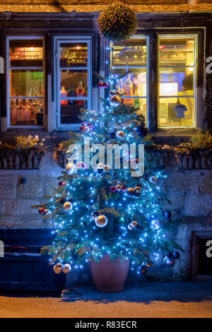 Eckschrank Inn und Weihnachtsbäume in der Nacht. Winchcombe, Cotswolds, Gloucestershire, England Stockfoto