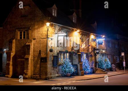 Eckschrank Inn und Weihnachtsbäume in der Nacht. Winchcombe, Cotswolds, Gloucestershire, England Stockfoto