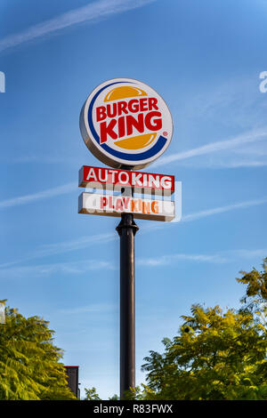 Valencia, Spanien - 12. Dezember 2018: Eine grosse abgerundete Burger King, Auto König und Playking Zeichen gegen den blauen Himmel. Große schwarze Post. Grüne Bäume auf beiden Seiten Stockfoto