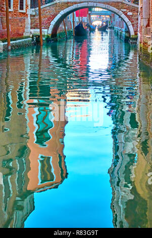 Venezianischer Spiegel - Häuser, blauer Himmel und die kleine Brücke im Wasser von einer Seite canal widerspiegeln. Venedig im Wasser Reflexionen Stockfoto