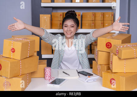 Erfolgreiche junge Unternehmerin mit Paketboxen in Ihren eigenen job shopping Online Business at home office Stockfoto