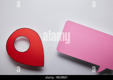 Blick von oben auf die leeren rosa Sprechblase und roten geo Pin auf grauem Hintergrund Stockfoto