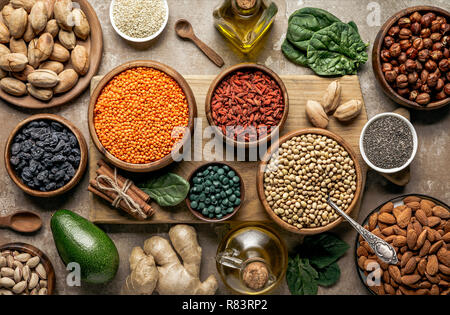 Flach auf Holzbrett mit Hülsenfrüchte, Goji Beeren und gesunden Zutaten auf Tisch Stockfoto