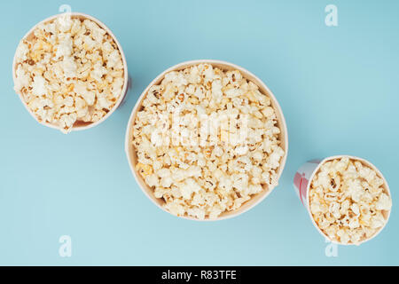 Blick von oben auf die gestreiften popcorn Eimern in verschiedenen Größen isoliert auf Blau Stockfoto