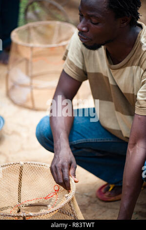 Mali, Afrika - schwarze afrikanische jungen Mann sammeln und die Zubereitung von Fisch Körbe im Niger, Stockfoto