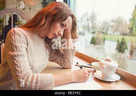 Traurige junge Frau schreiben Brief mit gebrochenen Herzen Verzweiflung Stockfoto