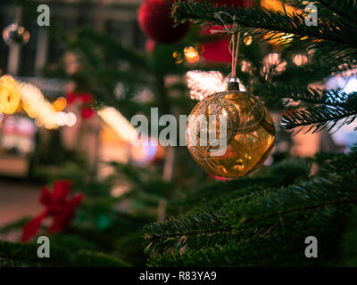 Goldene Christbaumkugel hängen von grünen Zweigen Stockfoto