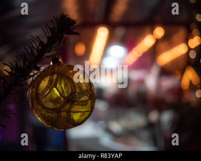 Goldene Christbaumkugel hängen von grünen Zweigen Stockfoto