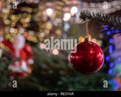 Rote Christbaumkugel hängen von grünen Zweigen Stockfoto