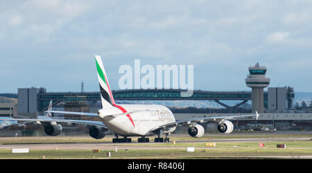 Flughafen Gatwick, Großbritannien - 09 Dezember 2018: Die Fluggesellschaft Emirates Airline Airbus A380 Taxis nach der Landung am Flughafen London Gatwick, plus Air Traffic Control Tower. Stockfoto